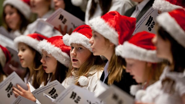 ARCHIV - 20.12.2011, Sachsen, Dresden: ARCHIV - SYMBOLBILD - Kinder mit Weihnachtsmann-Mützen tragen am 20.12.2011 in Dresden Lieder vor. Weihnachten ohne das Lied «O du fröhliche» - das geht für viele Menschen gar nicht. Foto: Oliver Killig/dpa-Zentralbild/dpa - Honorarfrei nur für Bezieher des Dienstes dpa-Nachrichten für Kinder +++ dpa-Nachrichten für Kinder +++ +++ dpa-Bildfunk +++