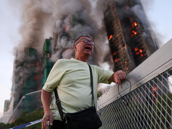 Wong 71, reacts after claiming his wife is trapped inside Wang Fuk Court during a major fire, in Tai Po, Hong Kong, China, November 26, 2025. REUTERS/Tyrone Siu