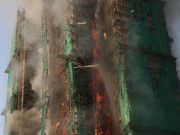 Smoke rises as flames engulf bamboo scaffolding across multiple buildings at Wang Fuk Court housing estate, in Tai Po, Hong Kong, China, November 26, 2025. REUTERS/Tyrone Siu