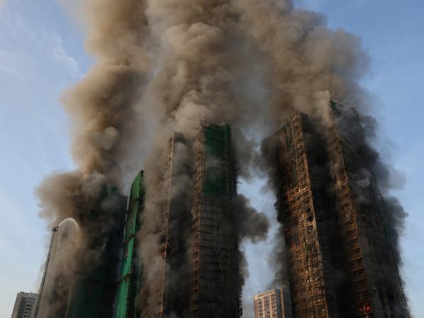 Smoke rises as flames engulf bamboo scaffolding across multiple buildings at Wang Fuk Court housing estate, in Tai Po, Hong Kong, China, November 26, 2025. REUTERS/Tyrone Siu