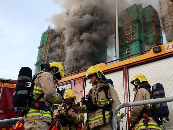 Firefighters work as efforts are underway to extinguish flames engulfing bamboo scaffolding across multiple buildings at the Wang Fuk Court housing estate in Tai Po, Hong Kong, China, November 26, 2025. REUTERS/Tyrone Siu