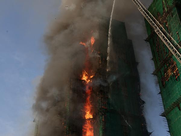 Efforts are underway to extinguish flames engulfing bamboo scaffolding across multiple buildings at the Wang Fuk Court housing estate in Tai Po, Hong Kong, China, November 26, 2025. REUTERS/Tyrone Siu