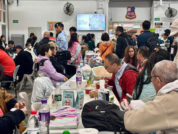Residents take refuge in a temporary shelter near the Wang Fuk Court residential estate in Hong Kong's Tai Po district on November 26, 2025. A huge fire engulfed a crowded Hong Kong high-rise complex, killing at least 36 people and leaving more than 200 unaccounted for in the city's worst blaze in decades. (Photo by Tommy WANG / AFP)