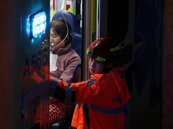 A person receives medical attention, after a fire started across multiple buildings at Wang Fuk Court housing estate, in Tai Po, Hong Kong, China, November 26, 2025. REUTERS/Tyrone Siu