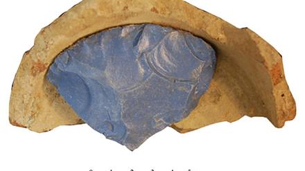 Fragment eines Rohglasbarren in einem Keramiktiegel