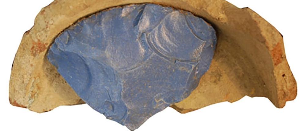 Fragment eines Rohglasbarren in einem Keramiktiegel