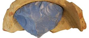 Fragment eines Rohglasbarren in einem Keramiktiegel