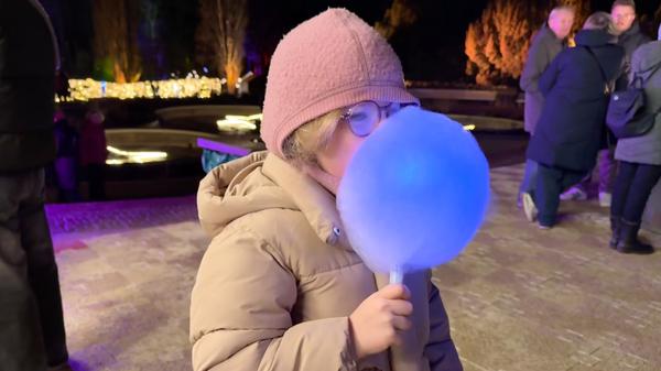Christmas Garden 2025 im Berliner Botanischen Garten: Ein Highlight ist die leuchtende Zuckerwatte. Testesserin ist die sechsjährige Sofia aus Prenzlauer Berg.