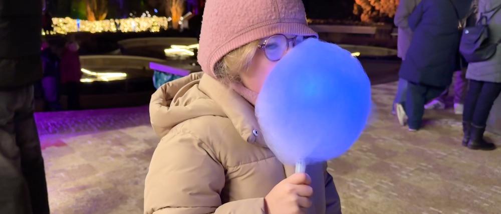 Christmas Garden 2025 im Berliner Botanischen Garten: Ein Highlight ist die leuchtende Zuckerwatte. Testesserin ist die sechsjährige Sofia aus Prenzlauer Berg.