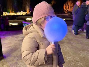 Christmas Garden 2025 im Berliner Botanischen Garten: Ein Highlight ist die leuchtende Zuckerwatte. Testesserin ist die sechsjährige Sofia aus Prenzlauer Berg.