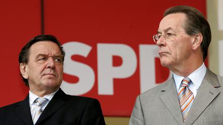 Der damalige Bundeskanzler Gerhard Schröder (l.) und der ehemalige SPD-Vorsitzende Franz Müntefering schauen am 17.09.2005 auf einer SPD-Wahlkampfveranstaltung in Recklinghausen in unterschiedliche Richtungen. 