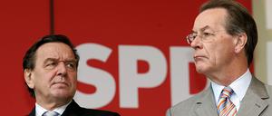 Der damalige Bundeskanzler Gerhard Schröder (l.) und der ehemalige SPD-Vorsitzende Franz Müntefering schauen am 17.09.2005 auf einer SPD-Wahlkampfveranstaltung in Recklinghausen in unterschiedliche Richtungen. 
