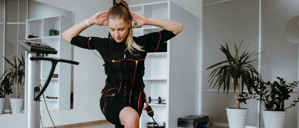 Eine Frau macht EMS-Training zu Hause. Mit Übungen kombiniert, ist es noch effektiver.