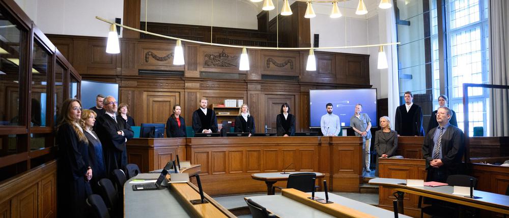 Die Prozessbeteiligten (l-r), die Rechtsanwälte des Angeklagten, Klaudia Dawidowic, Ria Halbritter und Christoph Stoll, sowie die Vorsitzende Richterin Sylvia Busch (M) und Staatsanwalt Philipp Meyhöfer (2.v.r.) stehen beim Mordprozess gegen einen Palliativarzt, der in Berlin 15 Menschen getötet haben soll, im Landgericht Berlin.