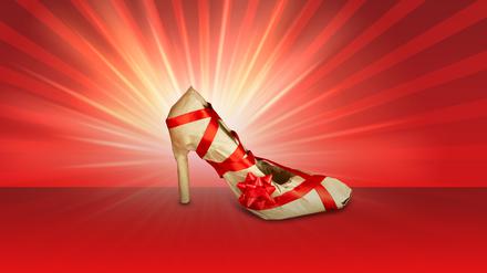 Ein Stöckelschuh ist in Papier verpackt und mit einer roten Schleife versehen. (Symbolbild)