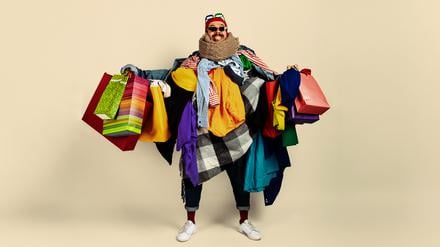 Ein Mann mit Dutzenden Einkaufstüten.