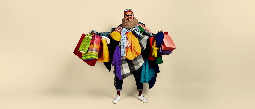 Ein Mann mit Dutzenden Einkaufstüten.