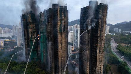 Ein Luftbild zeigt Rauch und Flammen, die aufsteigen, als am 27. November 2025 ein Großbrand mehrere Wohngebäude im Wang Fuk Court in Hongkong erfasst.