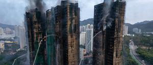 Ein Luftbild zeigt Rauch und Flammen, die aufsteigen, als am 27. November 2025 ein Großbrand mehrere Wohngebäude im Wang Fuk Court in Hongkong erfasst.