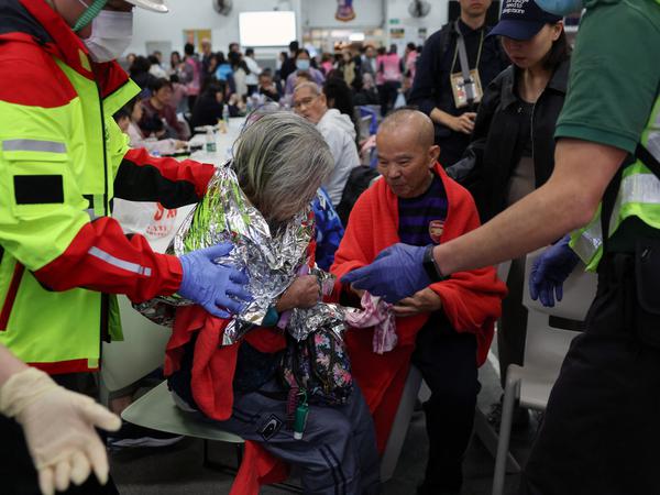 A woman receives medical attention at a temporary shelter, after a fire started across multiple buildings at Wang Fuk Court housing estate, in Tai Po, Hong Kong, China, November 26, 2025. REUTERS/Tyrone Siu