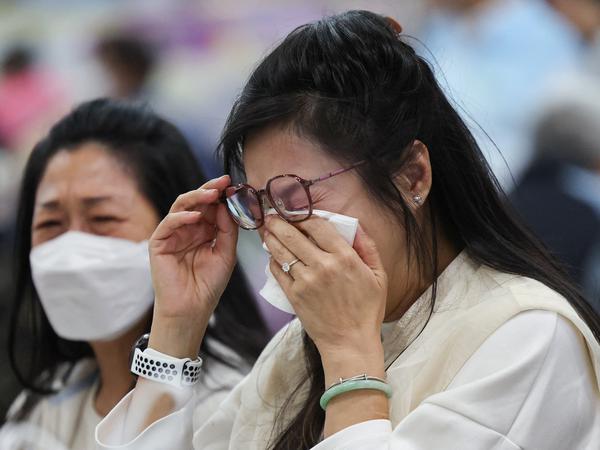 A woman reacts at a temporary shelter, after a fire started across multiple buildings at Wang Fuk Court housing estate, in Tai Po, Hong Kong, China, November 26, 2025. REUTERS/Tyrone Siu