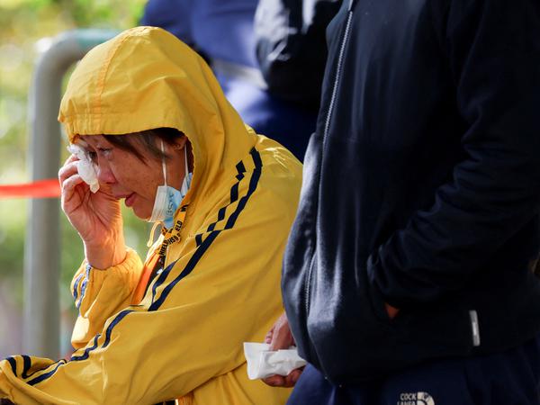 A woman reacts outside the Kwong Fuk Community Hall where relatives identify family members from photos, following the Wang Fuk Court housing complex fire, in Tai Po, Hong Kong, China, November 28, 2025. REUTERS/Tyrone Siu