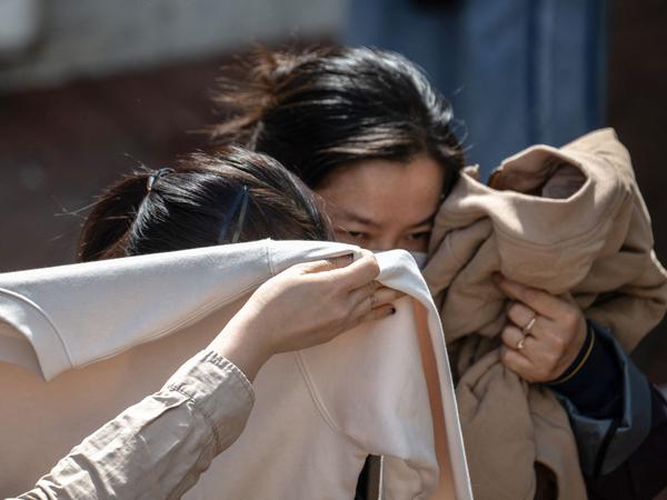 People leave after identifying bodies in the aftermath of a major fire that swept through several apartment blocks at the Wang Fuk Court residential estate in Hong Kong's Tai Po district on November 28, 2025. Firefighters searched the last of the housing estate flats torched by Hong Kong's worst fire in decades on November 28, with the death toll rising to at least 94 overnight and scores still missing. (Photo by Philip FONG / AFP)