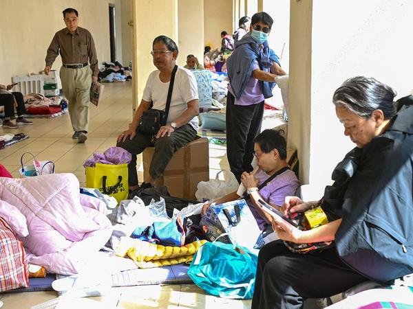 Displaced residents are seen at a makeshift shelter inside a shopping mall near the scene of a major fire that swept through several apartment blocks at the Wang Fuk Court residential estate in Hong Kong's Tai Po district on November 28, 2025. Firefighters searched the last of the housing estate flats torched by Hong Kong's worst fire in decades on November 28, with the death toll rising to at least 94 overnight and scores still missing. (Photo by Peter PARKS / AFP)