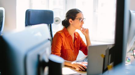 Eine Frau arbeitet an einem Computer im Büro.