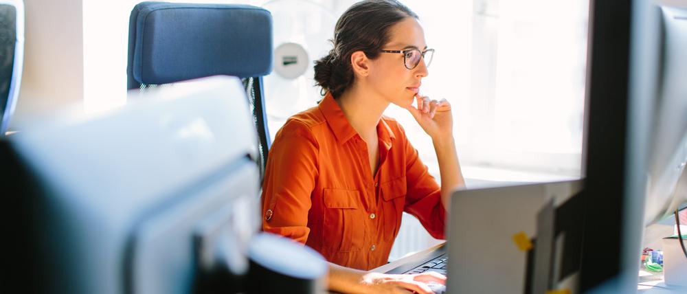 Eine Frau arbeitet an einem Computer im Büro.