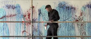 Imran Qureshi mit Pinsel Größe 14 und einem Becher mit Farbe, den er immer wieder an der Wand ausgießt. F