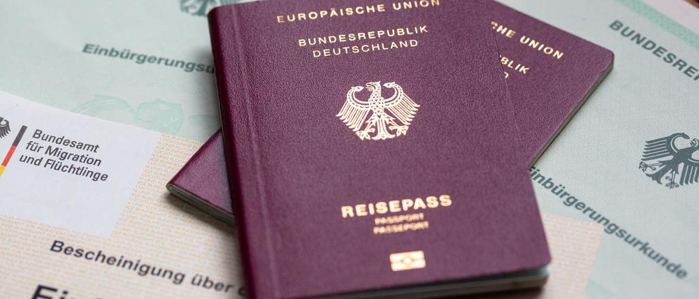 Zwei deutsche Reisepässe liegen auf Einbürgerungsurkunden der Bundesrepublik Deutschland sowie einem Einbürgerungstest.