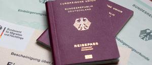Zwei deutsche Reisepässe liegen auf Einbürgerungsurkunden der Bundesrepublik Deutschland sowie einem Einbürgerungstest.