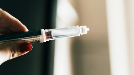 Eine Hand hält eine Abnehmspritze.