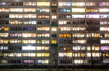 In einem Hochhaus in Lichtenberg sind einige Fenster beleuchtet. Die Zahl der Sozialwohnungen in Berlin sinkt.