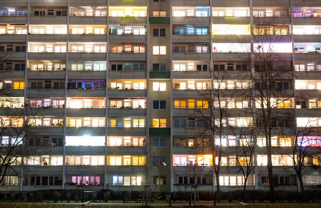 In einem Hochhaus in Lichtenberg sind einige Fenster beleuchtet. Die Zahl der Sozialwohnungen in Berlin sinkt.