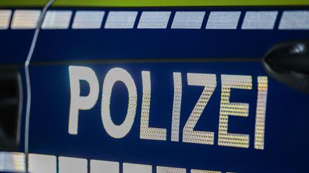 Der Schriftzug «Polizei» reflektiert an einem Streifenwagen.