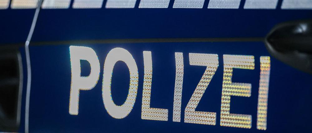 Der Schriftzug «Polizei» reflektiert an einem Streifenwagen.