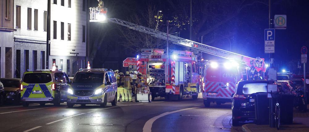 Rettungskräfte arbeiten an einer Fassade eines Mehrfamilienhauses, die nach einer Explosion beschädigt wurde.