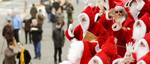 Eine Gruppe von Weihnachtsmännern mit Rauschebärten und rot-weißen Mänteln. 