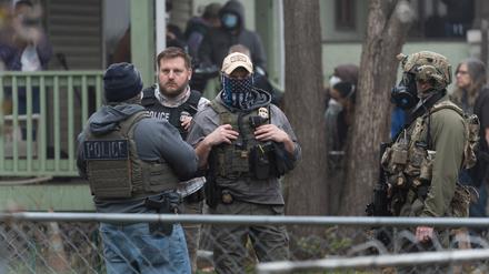Beamte der US-Einwanderungsbehörde ICE und anderer Behörden stehen während einer Razzia in einem Haus in St. Paul, Minnesota, Wache (Symbolbild).