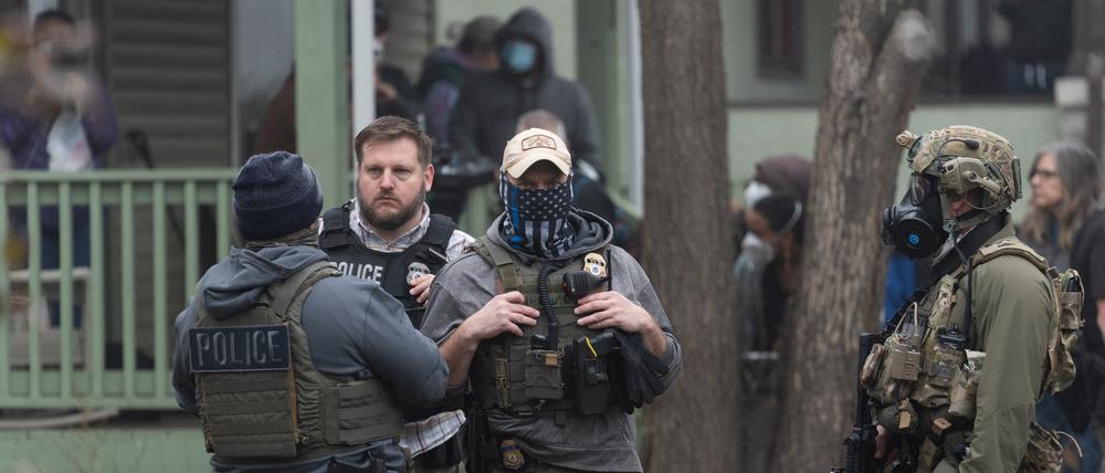 Beamte der US-Einwanderungsbehörde ICE und anderer Behörden stehen während einer Razzia in einem Haus in St. Paul, Minnesota, Wache (Symbolbild).