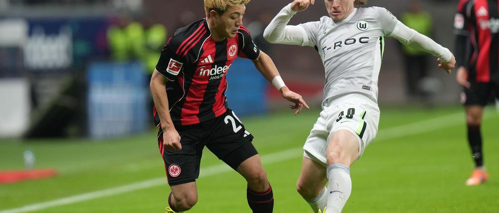 Lieferten sich eine umkämpfte Partie: Eintracht Frankfurt um Ritsu Doan (l) und der VfL Wolfsburg um Patrick Wimmer (r).