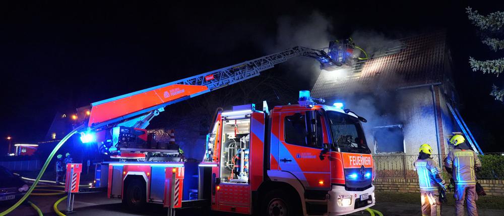 Feuerwehrleute sind im Einsatz bei einem Brand in einem Einfamilienhaus - ein Kind kam ums Leben.