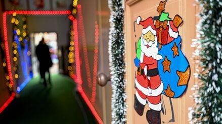 Der Eingang zum Glühweinhof in der Potsdamer Innenstadt ist mit bunten Lichtern und einem Weihnachtsmann dekoriert.