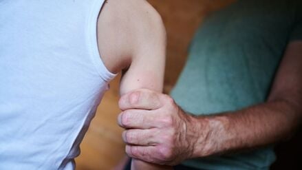 Ein Mann hält ein Kind fest am Arm (gestellte Szene).