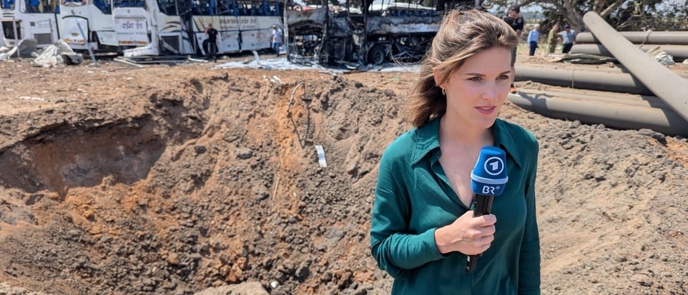 Sophie von der Tann berichtet aus dem Norden von Tel Aviv. Im Hintergrund hat ein iranischer Raketenangriff einen Krater gerissen. (Juni 2025)