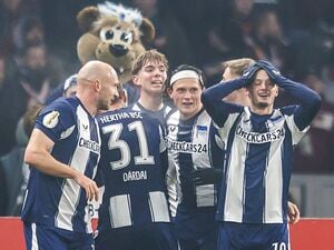Jubelnde Hertha-Spieler mit Maskottchen.