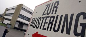 Ein Hinweisschild mit der Aufschrift «Zur Musterung» vor einem Kreiswehrersatzamt.