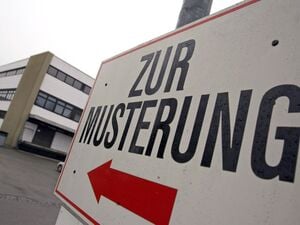 Ein Wehrpflichtiger steht unter einem Hinweisschild mit der Aufschrift „Zur Musterung“ vor dem Kreiswehrersatzamt in Kempten (Schwaben). (Symbolbild)